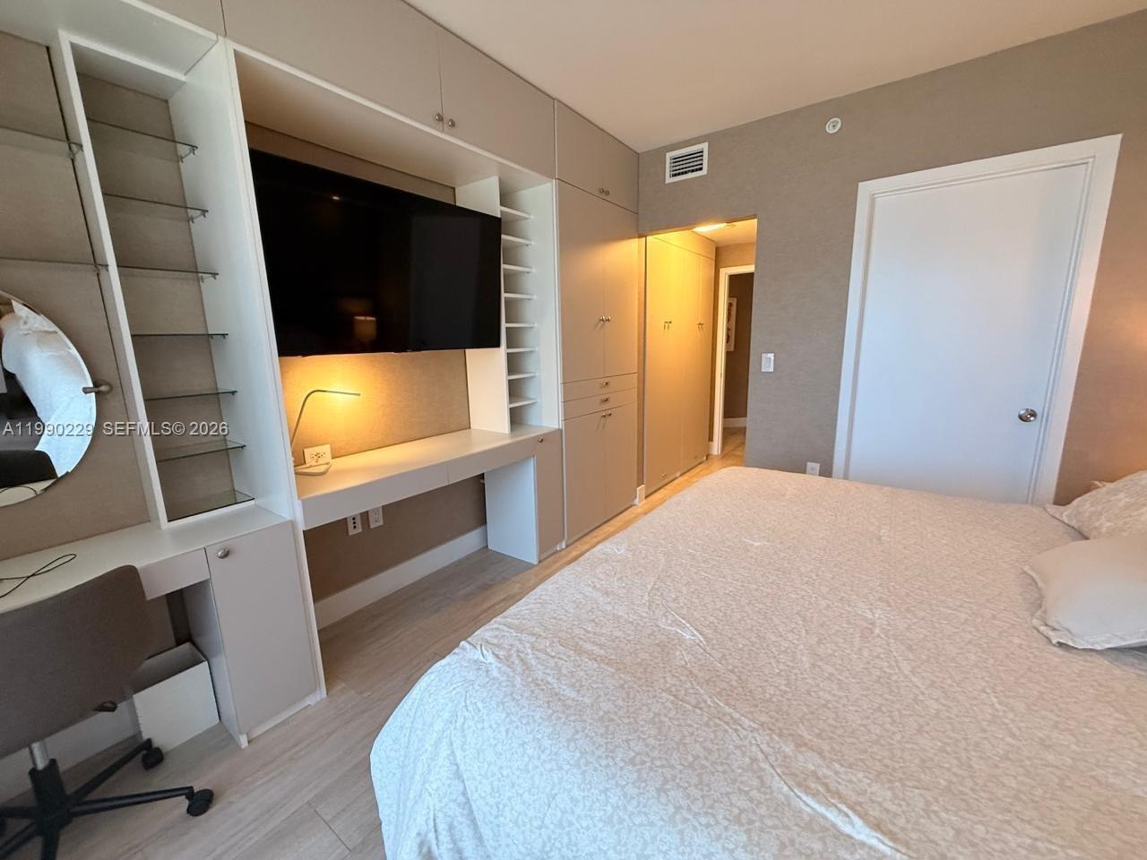 45 Southwest 9th Street, Unit 1401 Miami, FL 33130 - Photo 10 of 17 a bedroom with a bed and a flat tv screen
