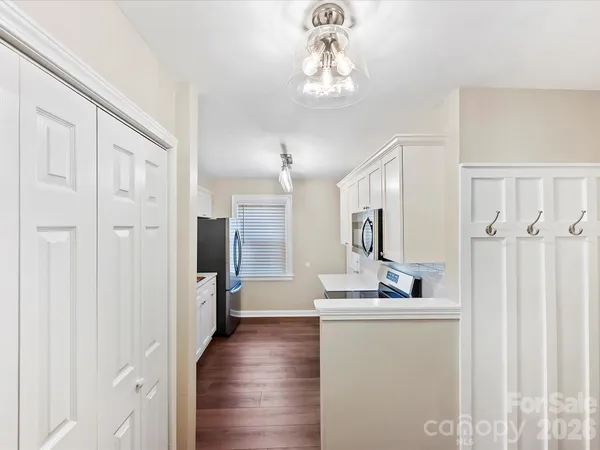 a view of a hallway with wooden floor and chandelier