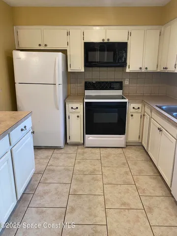 a kitchen with cabinets and steel appliances