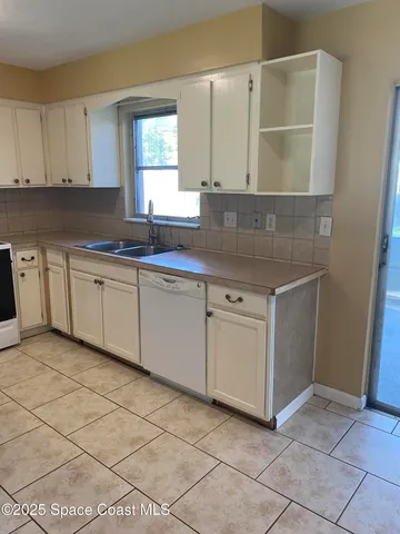 a kitchen with cabinets and window
