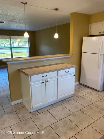 a kitchen with a sink a refrigerator and window