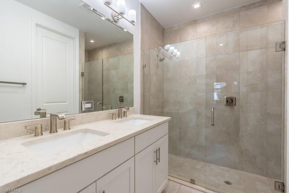7565 Carnegie Way Naples, FL 34119 - Photo 22 of 50 Bathroom with double vanity, a stall shower, and recessed lighting