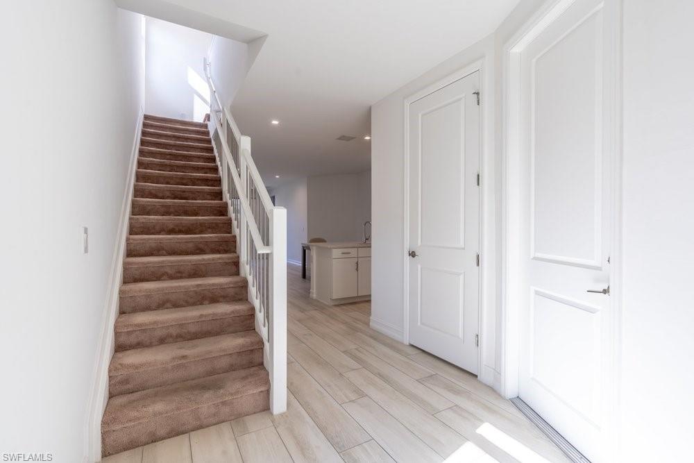 7565 Carnegie Way Naples, FL 34119 - Photo 3 of 50 Stairs featuring wood finish floors and recessed lighting