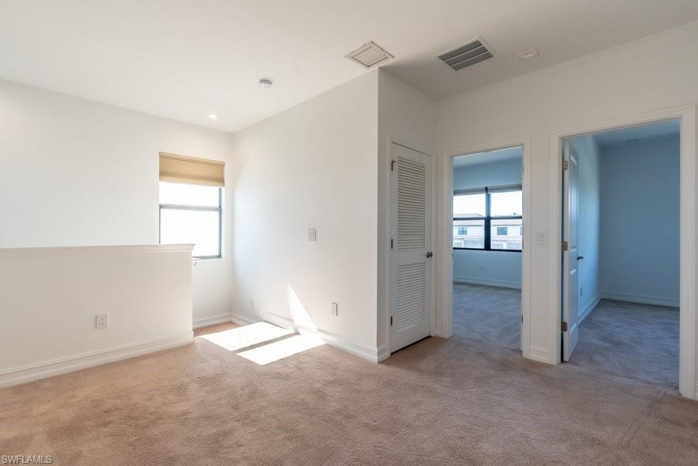 7565 Carnegie Way Naples, FL 34119 - Photo 32 of 50 Spare room with plenty of natural light and light colored carpet