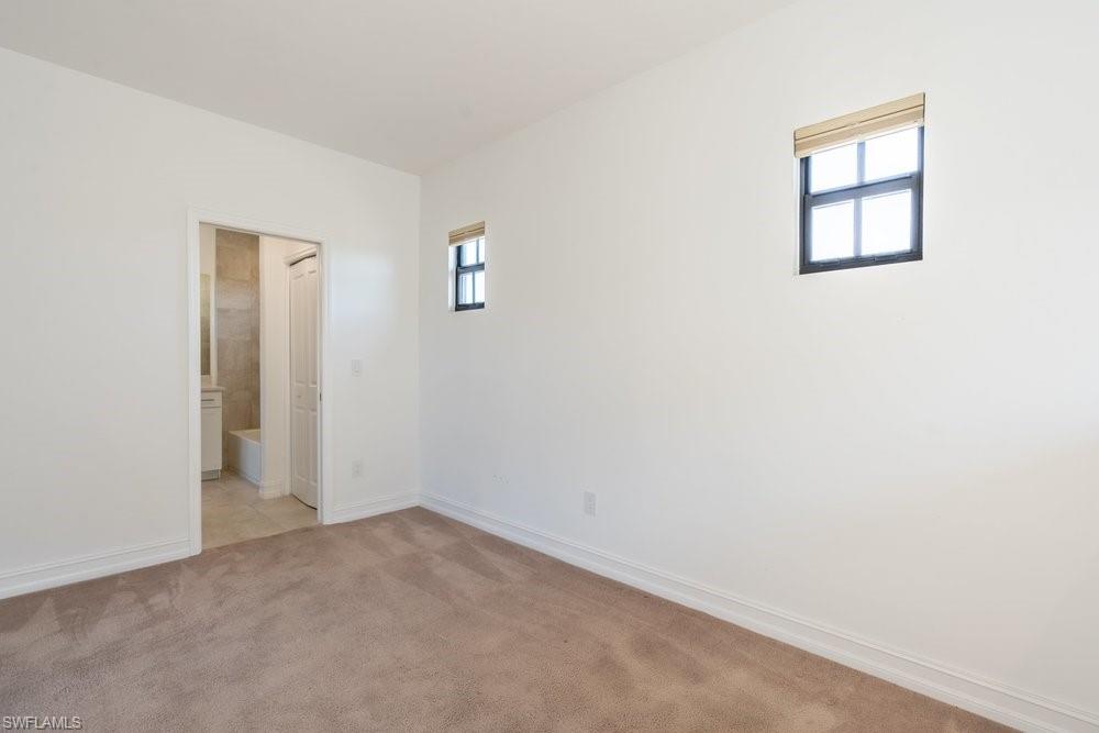 7565 Carnegie Way Naples, FL 34119 - Photo 37 of 50 Unfurnished bedroom with light colored carpet and ensuite bath