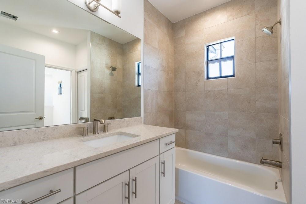 7565 Carnegie Way Naples, FL 34119 - Photo 38 of 50 Bathroom featuring vanity and shower / bathtub combination