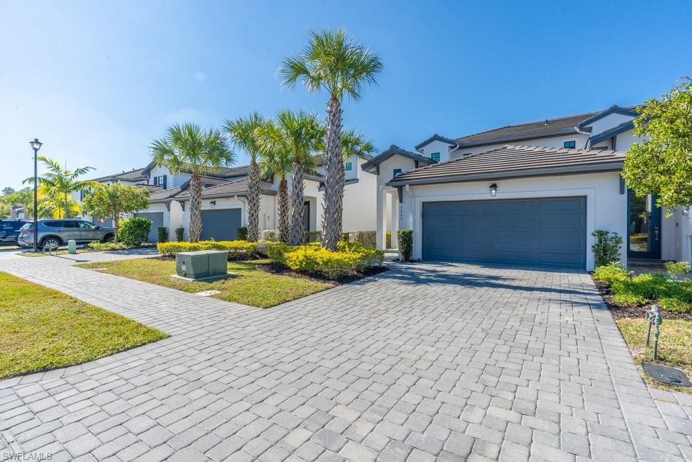 7565 Carnegie Way Naples, FL 34119 - Photo 39 of 50 View of front of property with decorative driveway, stucco siding, a garage, and a tile roof