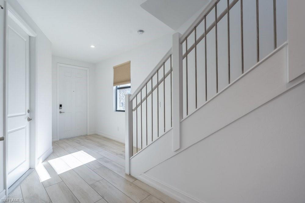 7565 Carnegie Way Naples, FL 34119 - Photo 4 of 50 Entryway with wood finish floors and stairs