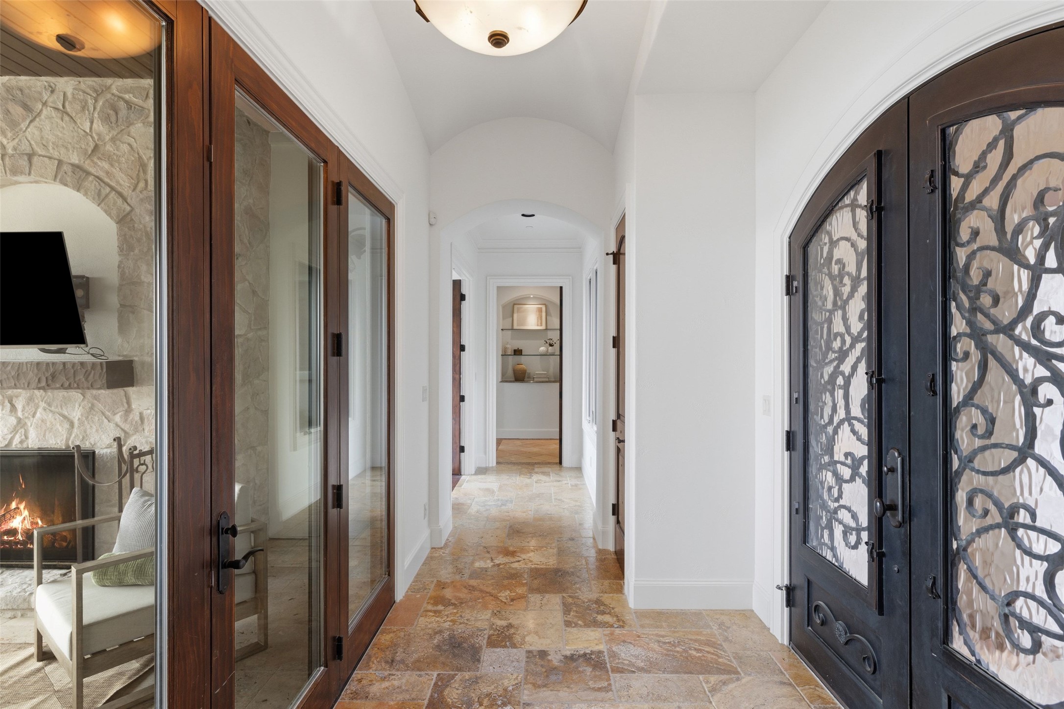 1414 The High Road Austin, TX 78746 - Photo 8 of 40 Ornate wrought iron doors open to a sun-drenched hallway with exquisite tile flooring.
