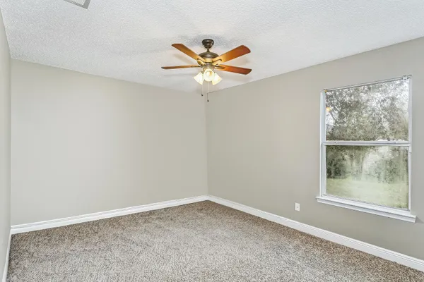 an empty room with closet and a ceiling fan