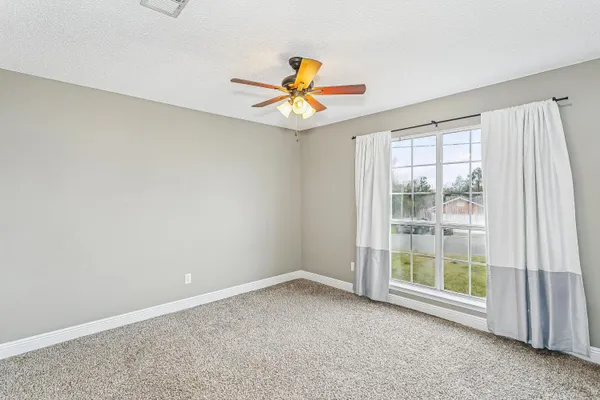 a bedroom with a bed a mirror and a potted plant