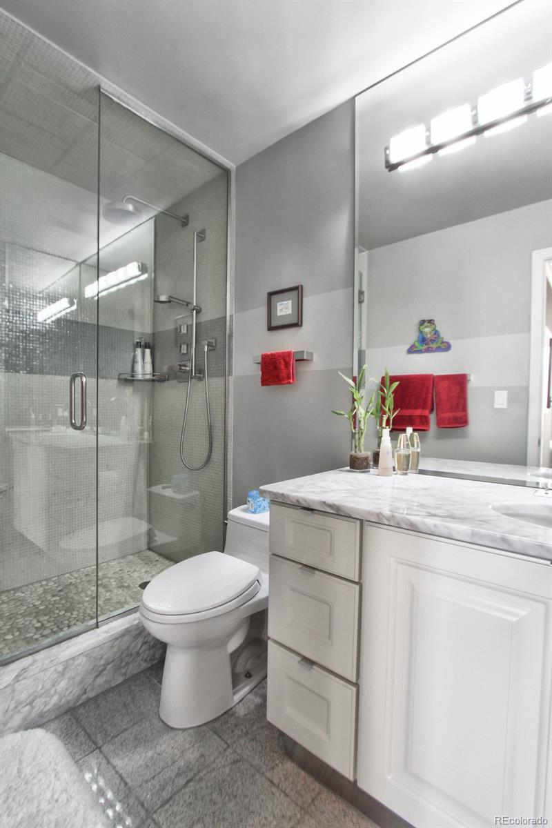 1625 Larimer Street, Unit 3104 Denver, CO 80202 - Photo 21 of 31 a bathroom with a granite countertop toilet sink and shower