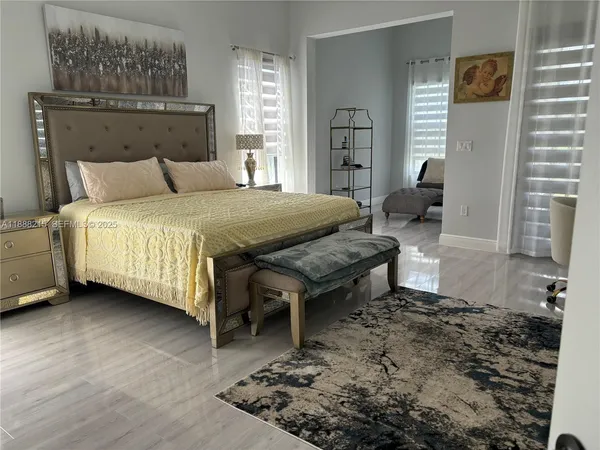 a spacious bedroom with a bed a table and chair