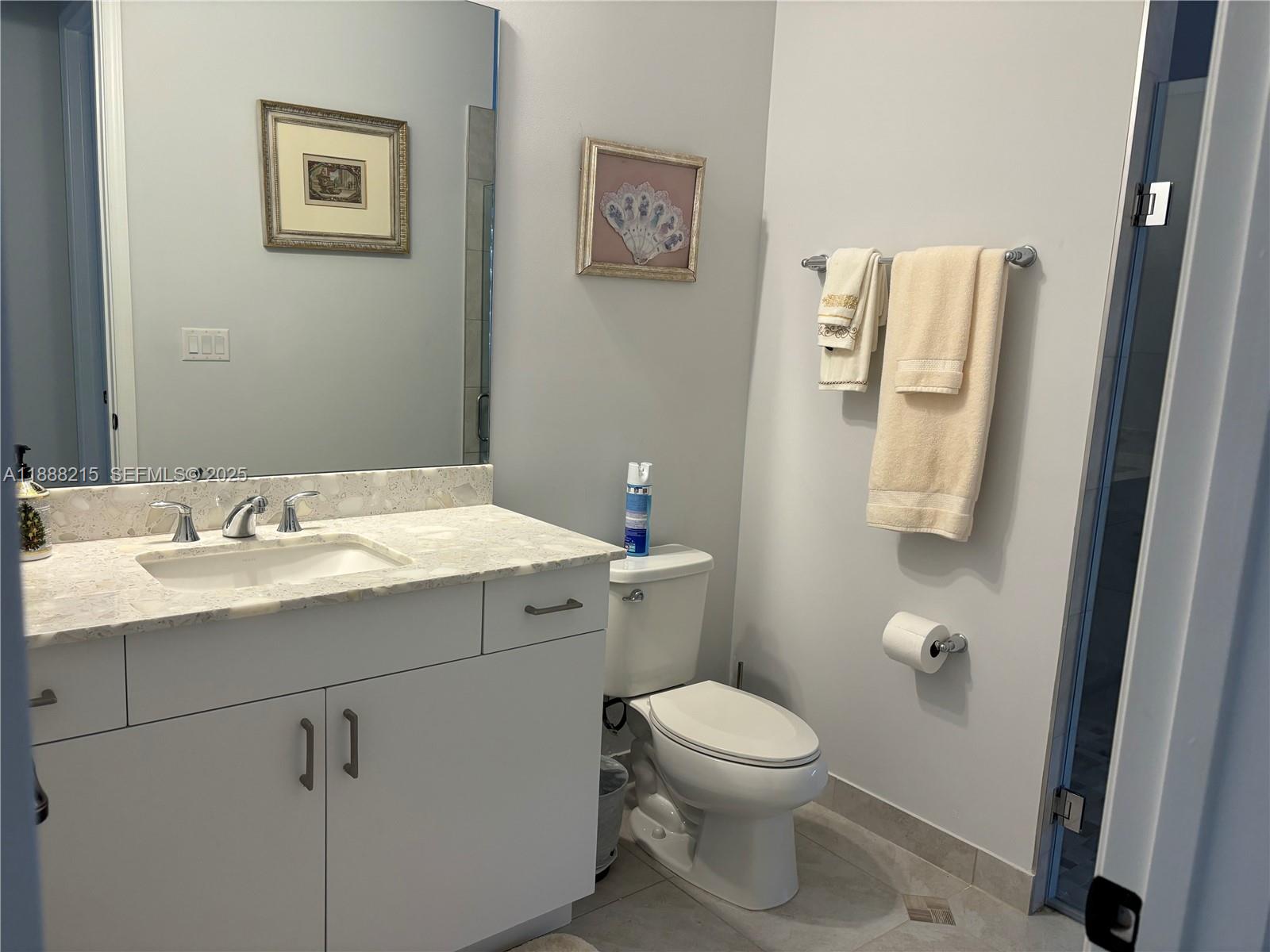 5107 Genoa Street, Unit 5107 Ave Maria, FL 34142 - Photo 15 of 16 a bathroom with a toilet sink and mirror