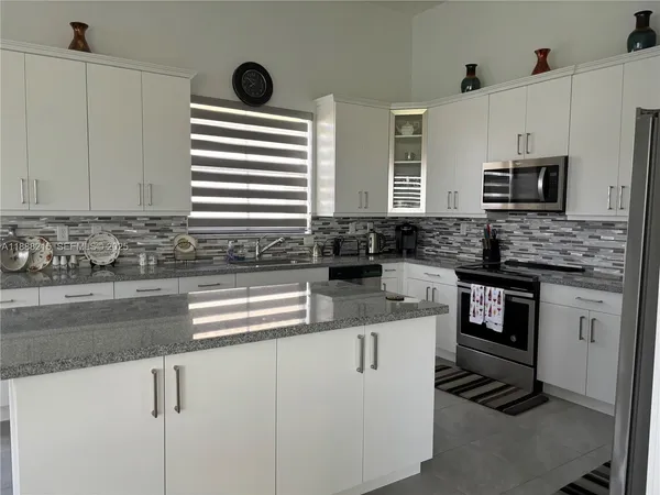 a kitchen with stainless steel appliances granite countertop a sink and a stove
