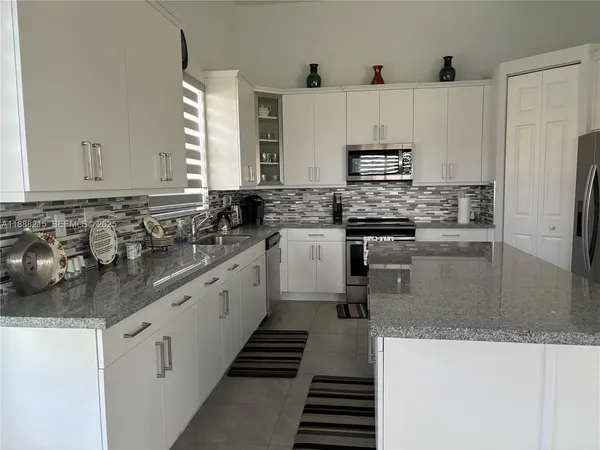 a kitchen with stainless steel appliances granite countertop a sink and a stove
