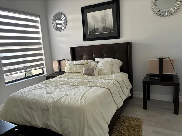 a bedroom with a bed and wooden floor