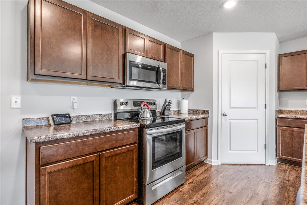 5320 Crossfield Road Memphis, TN 38109 - Photo 15 of 40 a kitchen with stainless steel appliances granite countertop a stove a sink and a microwave