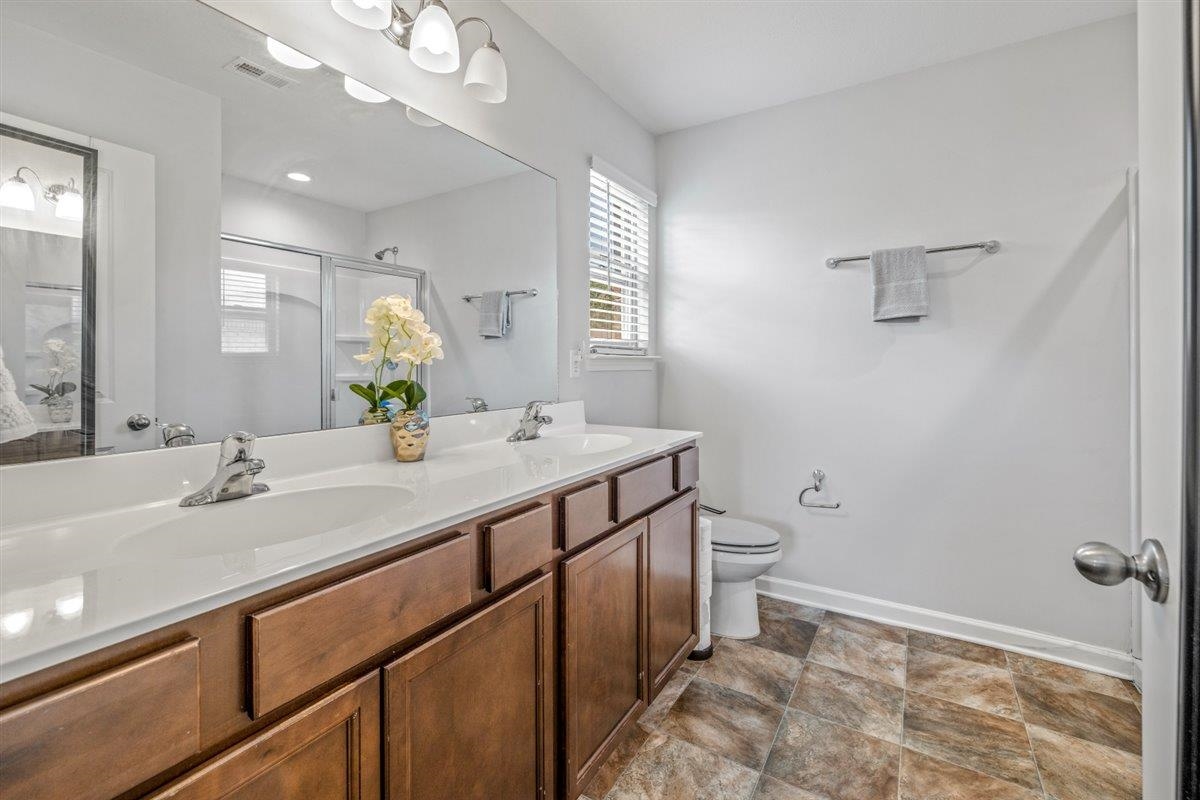 5320 Crossfield Road Memphis, TN 38109 - Photo 26 of 40 a bathroom with a granite countertop sink a toilet and a mirror