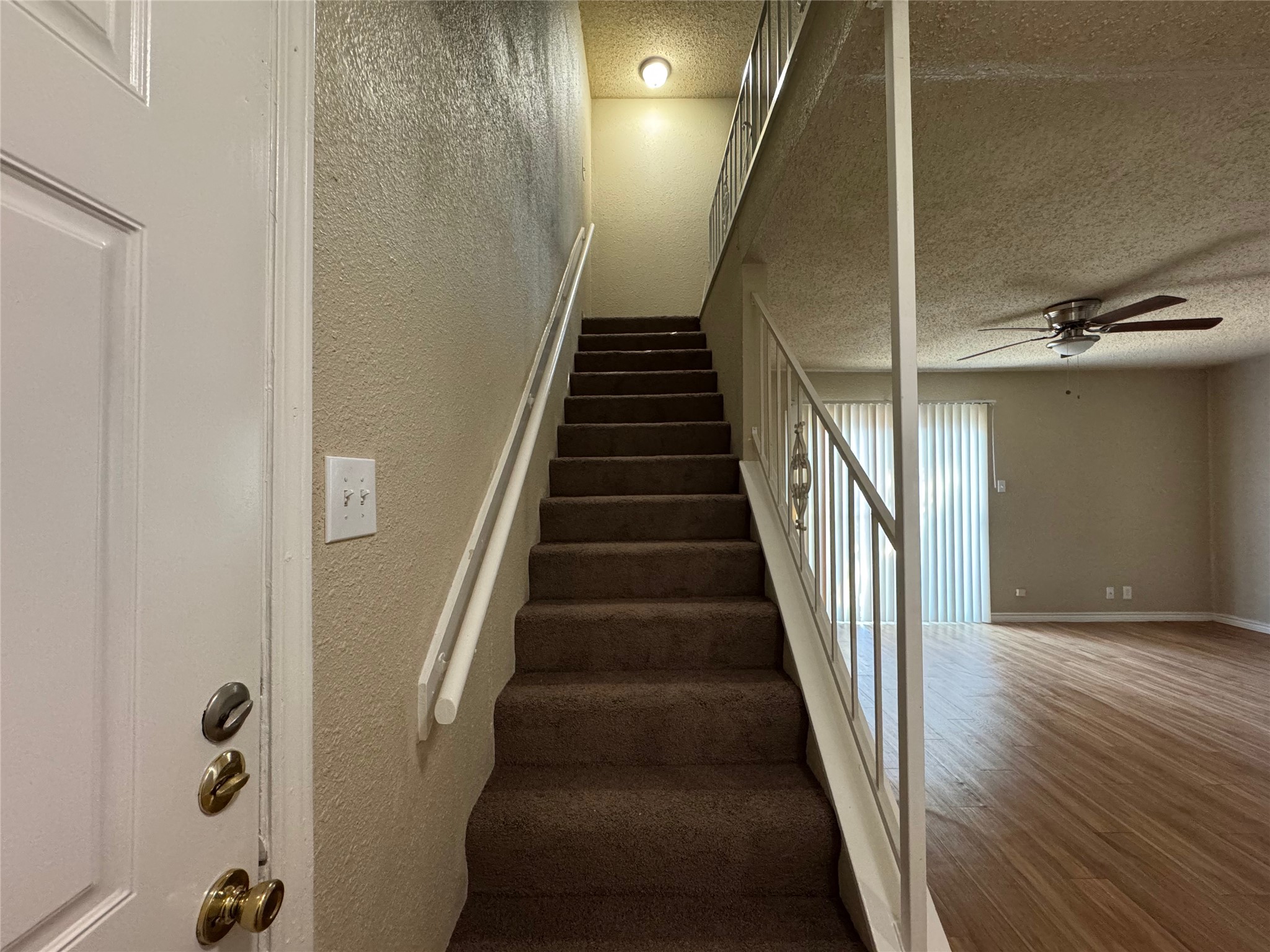 4902 West Wind Trail, Unit 101 Austin, TX 78745 - Photo 9 of 18 a view of staircase with wooden floor and lots of frames on wall