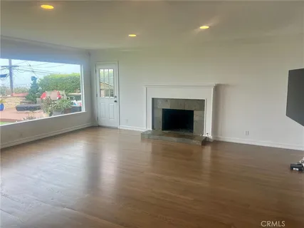 an empty room with wooden floor a fireplace