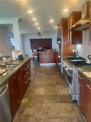 a kitchen with stainless steel appliances granite countertop a stove a sink and a refrigerator