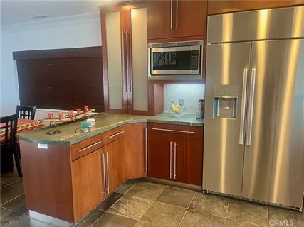 a kitchen with stainless steel appliances granite countertop a refrigerator and a stove