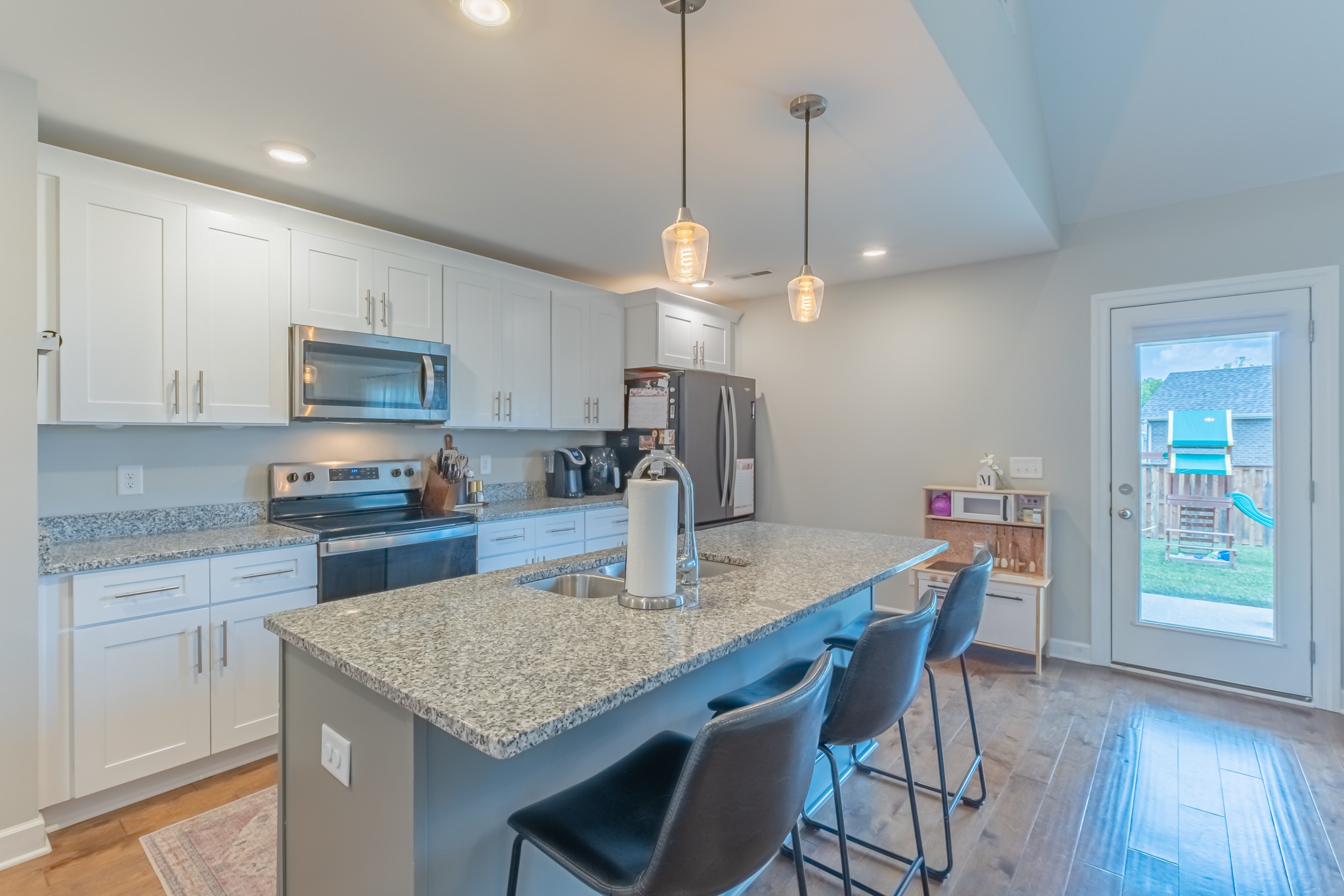 296 Spring Breeze Drive Tullahoma, TN 37388 - Photo 11 of 31 a kitchen with granite countertop kitchen island stainless steel appliances a dining table chairs sink and cabinets