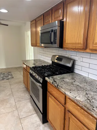 a kitchen with stainless steel appliances granite countertop a sink stove and microwave
