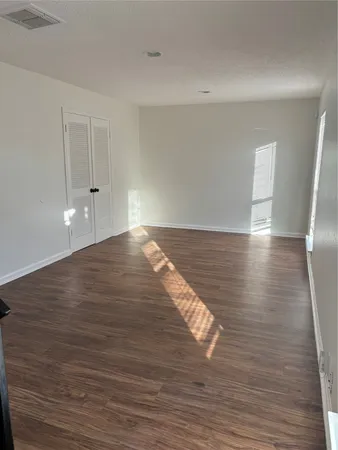 a view of empty room with wooden floor