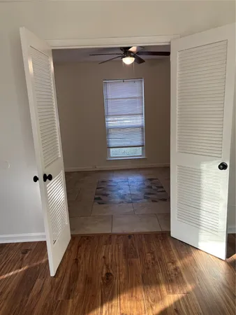a view of a hallway with wooden floor and closet