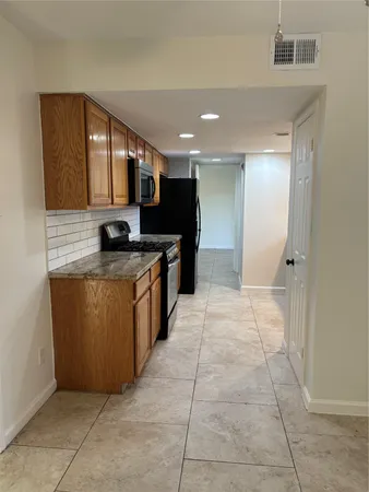 a kitchen with stainless steel appliances granite countertop a stove a sink and a microwave