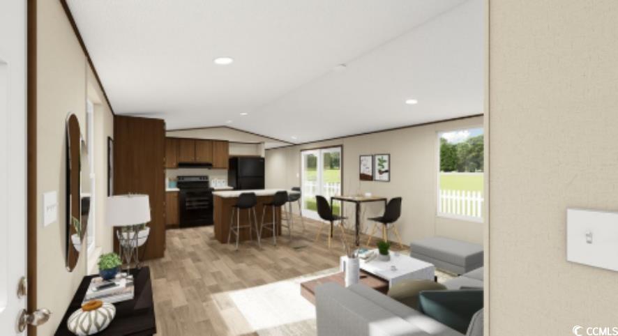 Living area with light wood finished floors, lofted ceiling, and recessed lighting