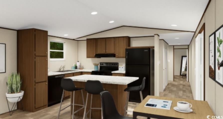 Kitchen featuring black appliances, a breakfast bar area, a center island, ventilation hood, and vaulted ceiling