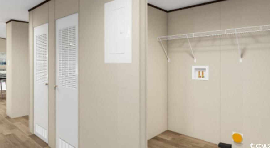 Washroom with wood finished floors and washer hookup