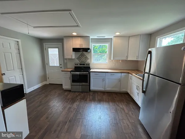 a view of a kitchen with granite countertop a stove top oven a sink and dishwasher