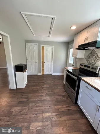 a large kitchen with stainless steel appliances a large counter top a stove and a refrigerator