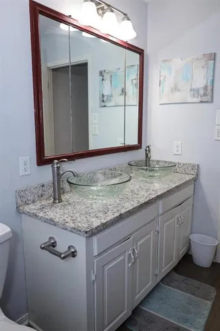 a bathroom with a granite countertop sink and a mirror