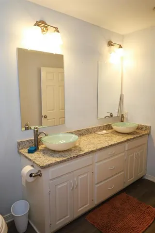 a bathroom with a granite countertop sink and a mirror