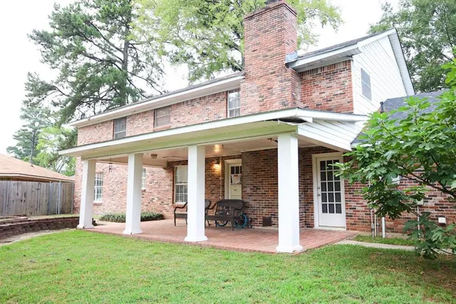 a view of a house with backyard and a tree