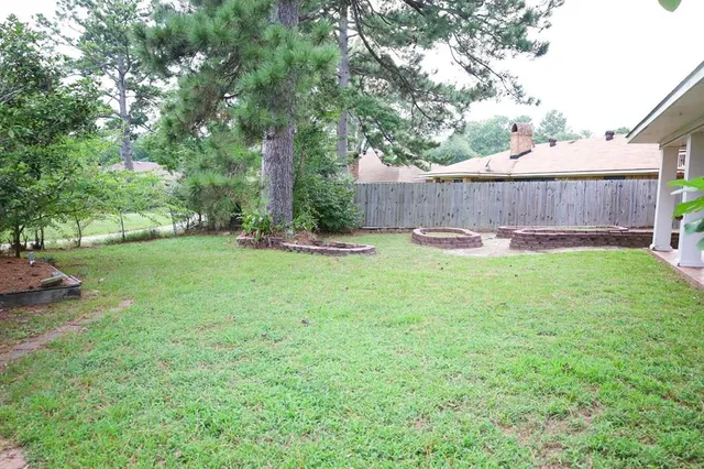 a backyard with table and chairs and wooden fence