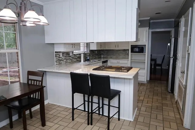 a kitchen with stainless steel appliances a table chairs and a refrigerator