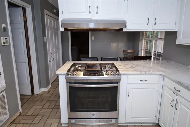 a stove top oven sitting inside of a kitchen