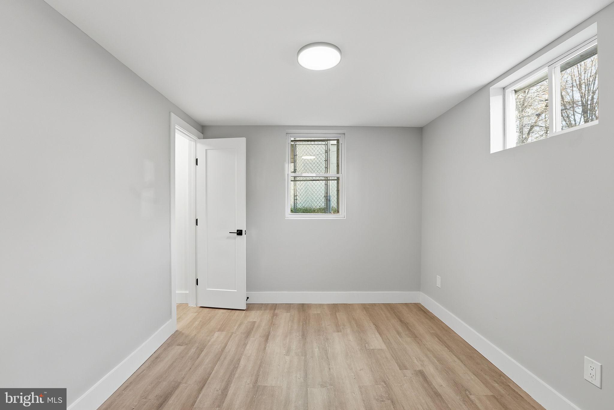 5716 Somerset Road Riverdale, MD 20737 - Photo 21 of 24 a view of an empty room with wooden floor and a window