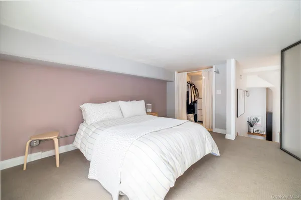 a bedroom with a bed and a refrigerator