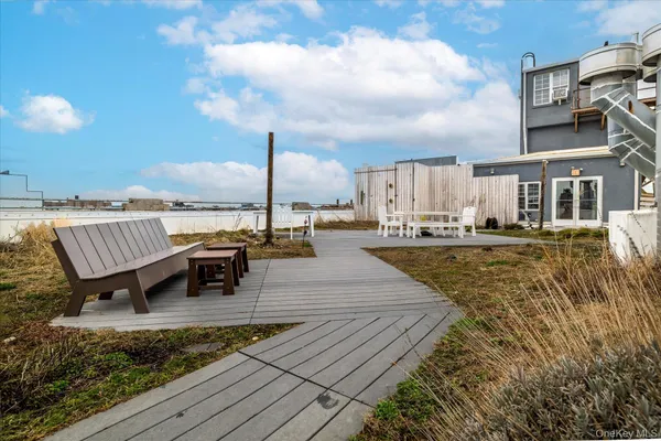 a view of a rooftop deck with couch and chairs