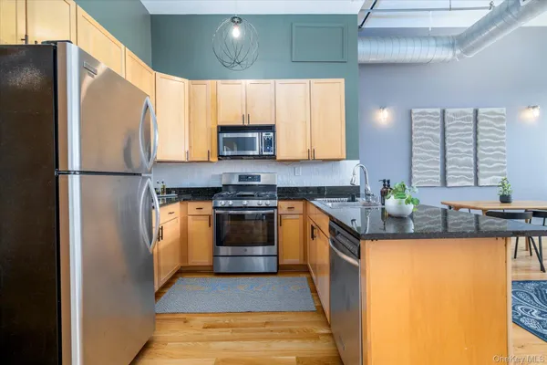 a kitchen with stainless steel appliances a refrigerator sink and stove
