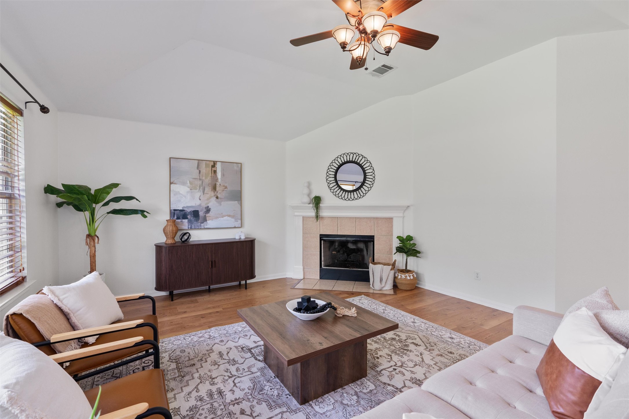 122 Copperwood Loop Round Rock, TX 78665 - Photo 7 of 40 Natural light illuminates this inviting living room, featuring a cozy fireplace and warm wood flooring.