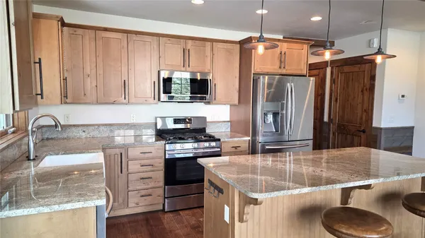 a kitchen with stainless steel appliances granite countertop a sink stove and refrigerator