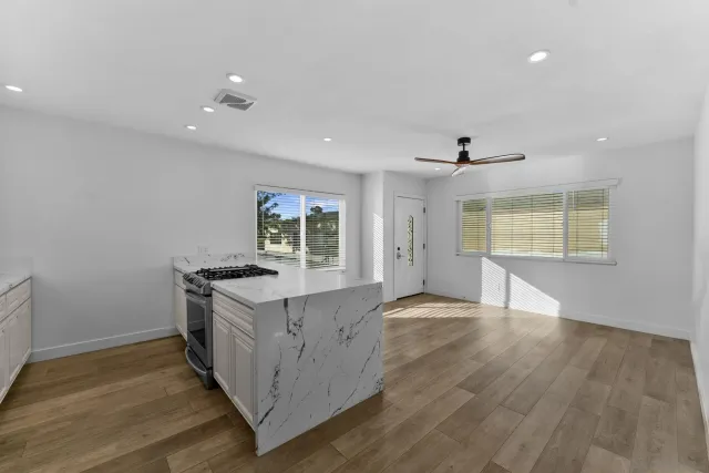 a kitchen with granite countertop a stove and a wooden floors